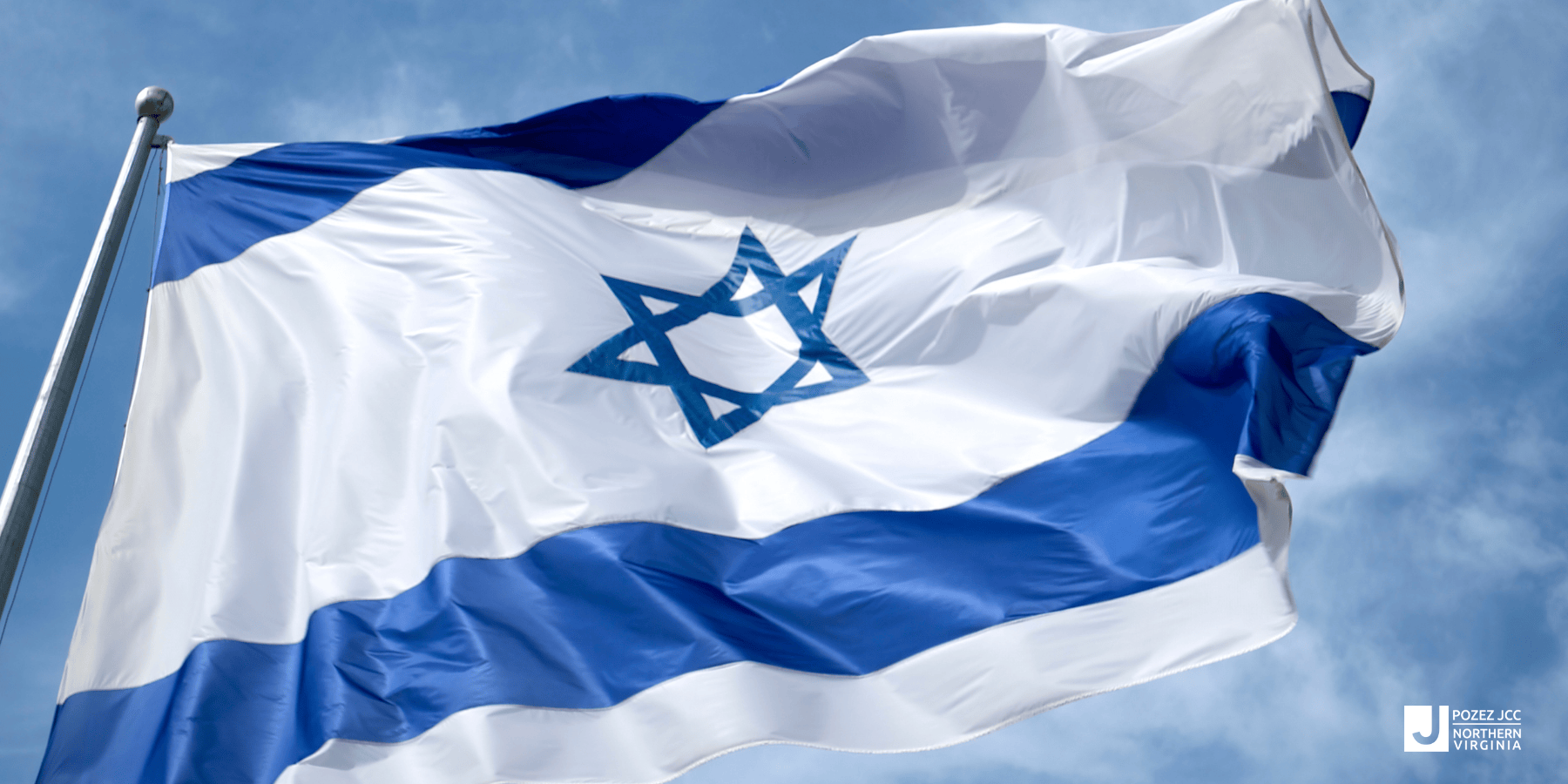 Israel flag in front of a blue sky.